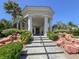 Elegant clubhouse entrance with stately columns, stone steps, lush landscaping, and cascading water features at 1813 Skyline Dr, Las Vegas, NV 89117
