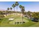 Scenic golf course showcasing mature palm trees, meticulously kept greens, sand traps, and a tranquil pond at 1813 Skyline Dr, Las Vegas, NV 89117
