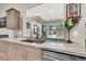 Modern kitchen sink and countertop with a view of the lush backyard pool and waterfall feature at 1813 Skyline Dr, Las Vegas, NV 89117