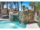 Pool with rock waterfall and surrounding tropical landscaping at 1813 Skyline Dr, Las Vegas, NV 89117