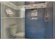 Modern shower with glass doors, blue tile and built-in niche for bathroom essentials and overhead rainfall shower at 1813 Skyline Dr, Las Vegas, NV 89117