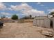 Large backyard features desert landscaping, storage sheds, and partial fencing at 1835 Banaba Ln, Las Vegas, NV 89156