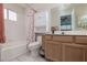 Neutral bathroom equipped with a tub-shower combination, white tile and single sink vanity at 1835 Banaba Ln, Las Vegas, NV 89156