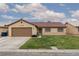 Charming single-story home featuring a red tile roof, a well-manicured lawn, and an attached two car garage at 1835 Banaba Ln, Las Vegas, NV 89156
