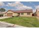 Charming single-story house featuring a red tile roof, a well-manicured lawn, and an attached two car garage at 1835 Banaba Ln, Las Vegas, NV 89156