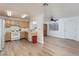 Bright kitchen featuring wood cabinets, white appliances, and wood-look tile flooring open to the living area at 1835 Banaba Ln, Las Vegas, NV 89156