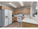 Bright kitchen featuring wood cabinets, white appliances, and tile floors at 1835 Banaba Ln, Las Vegas, NV 89156