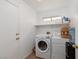 Functional laundry room with a washer, dryer, storage shelves, and access door at 1835 Banaba Ln, Las Vegas, NV 89156