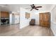 Open-concept living area boasts wood-look tile floors, white walls, a ceiling fan and a partial view of the kitchen at 1835 Banaba Ln, Las Vegas, NV 89156