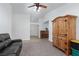 Cozy living room with plush carpeting, a ceiling fan, and a unique wood armoire at 1835 Banaba Ln, Las Vegas, NV 89156