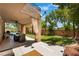 Covered backyard patio with lush landscaping, a dining area, and a private pool at 2008 Aspen Oak St, Las Vegas, NV 89134