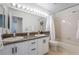 Bathroom featuring a double sink vanity, large mirror, and shower over tub at 2008 Aspen Oak St, Las Vegas, NV 89134