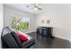 A bedroom has a modern black futon with bright red pillows and dark wood flooring at 2008 Aspen Oak St, Las Vegas, NV 89134