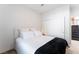 An interior view of a bedroom featuring a made bed with a black throw and neutral walls at 2008 Aspen Oak St, Las Vegas, NV 89134