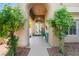 Inviting entryway with lush greenery leading to an arched doorway and double glass doors at 2008 Aspen Oak St, Las Vegas, NV 89134