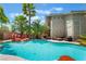 Beautiful backyard pool with rock accents, surrounded by lush landscaping and swaying palm trees, resort style living at 2008 Aspen Oak St, Las Vegas, NV 89134