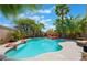 Private backyard pool with rock features, spa, and mature tropical landscaping, perfect for relaxation at 2008 Aspen Oak St, Las Vegas, NV 89134