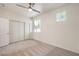 A bright bedroom with neutral carpet, a ceiling fan, and double door closet at 202 Twin Creek St, Henderson, NV 89074