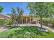 A beautiful backyard with green grass, trees, and an outdoor seating area at 2107 Desert Woods Dr, Henderson, NV 89012