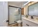 Modern bathroom featuring white vanity, glass shower with black trim and marble floor at 2107 Desert Woods Dr, Henderson, NV 89012