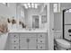 This is a brightly lit bathroom with a modern vanity, framed mirrors, and a shower with glass doors at 217 Turkey Creek Way, Henderson, NV 89074