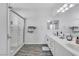 This bathroom has double sinks, a large mirror, and a walk-in shower with light wood-style vinyl flooring at 217 Turkey Creek Way, Henderson, NV 89074