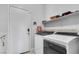 Well-lit laundry room with Whirlpool washer/dryer, storage shelves, and easy access exterior door at 217 Turkey Creek Way, Henderson, NV 89074