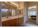 Bright bathroom with dual sinks, a large mirror, and walk-in shower, adjacent to the bedroom at 2173 Point Mallard Dr, Henderson, NV 89012