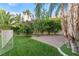 Landscaped backyard with green grass, manicured shrubs, and paved patio at 2309 Prometheus Ct, Henderson, NV 89074