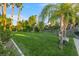 Beautifully landscaped backyard with a lush lawn, mature trees, and a charming swing chair at 2309 Prometheus Ct, Henderson, NV 89074