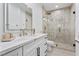 Bright bathroom showcasing a marble vanity, large mirror, and a glass-enclosed shower with gold accents at 2309 Prometheus Ct, Henderson, NV 89074