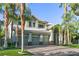 Beautiful home with a three-car garage, a tile roof, and mature palm trees in a well-maintained yard at 2309 Prometheus Ct, Henderson, NV 89074