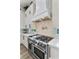 Gourmet kitchen with stainless steel oven, white cabinets, and designer backsplash at 2309 Prometheus Ct, Henderson, NV 89074