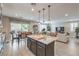 Open concept kitchen flows into the living room and dining area with large windows and hardwood flooring at 2711 Evolutionary Ln, Las Vegas, NV 89138