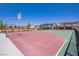 A community basketball court with two hoops sits between rows of colorful houses and is surrounded by fencing at 2773 Green Envy Ave # 245, North Las Vegas, NV 89086