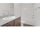 Bright bathroom with a granite countertop vanity, a shower-tub combo, and modern fixtures at 2773 Green Envy Ave # 245, North Las Vegas, NV 89086