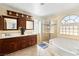 Bright bathroom boasts dual vanities, glass enclosed shower and a garden tub beneath a large arched window at 2829 Via Florentine St, Henderson, NV 89074
