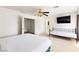 Spacious bedroom featuring light colored carpet, a television, ceiling fan, and multiple closets at 2829 Via Florentine St, Henderson, NV 89074