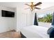 Bright bedroom features a large window and a television. It's also equipped with a ceiling fan at 2829 Via Florentine St, Henderson, NV 89074