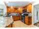 Kitchen with wood cabinets, granite countertops, tiled floors, and stainless steel appliances at 2829 Via Florentine St, Henderson, NV 89074