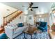 Inviting living room with staircase, wood floors, ceiling fan, and view to the dining area at 2829 Via Florentine St, Henderson, NV 89074