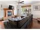 Comfortable living room with a fireplace, a ceiling fan, wood floors and large sectional sofa at 2829 Via Florentine St, Henderson, NV 89074