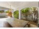 Covered outdoor dining area with a large table, built-in seating, and lush greenery at 2829 Via Florentine St, Henderson, NV 89074