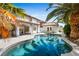 Backyard pool area with tropical landscaping and covered patio at 2829 Via Florentine St, Henderson, NV 89074