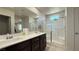 Bathroom showcasing a double sink vanity, large mirror, and a glass enclosed shower at 2924 Sunday Silence Rd, North Las Vegas, NV 89086