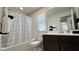 Bathroom featuring a shower-tub combo, vanity, and a decorative polka dot shower curtain at 2924 Sunday Silence Rd, North Las Vegas, NV 89086