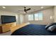 Well-lit bedroom features a ceiling fan, plush bed, and a large television at 2924 Sunday Silence Rd, North Las Vegas, NV 89086