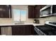 Well-lit kitchen showcasing stainless steel appliances, dark cabinets, and a bright window at 2924 Sunday Silence Rd, North Las Vegas, NV 89086