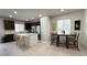 Bright eat-in kitchen featuring a center island, stainless steel appliances, and dark cabinetry at 2924 Sunday Silence Rd, North Las Vegas, NV 89086