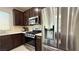 Modern kitchen featuring stainless steel appliances, dark wood cabinets, and light countertops at 2924 Sunday Silence Rd, North Las Vegas, NV 89086